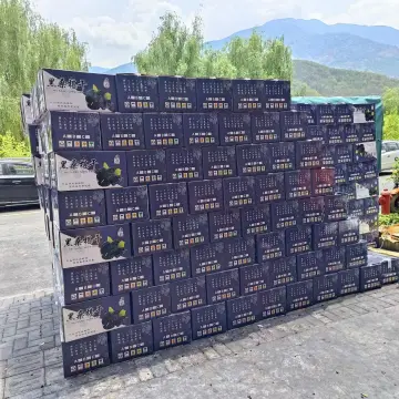 Large outdoor stack of purple mulberry product cartons prepared for wholesale shipment